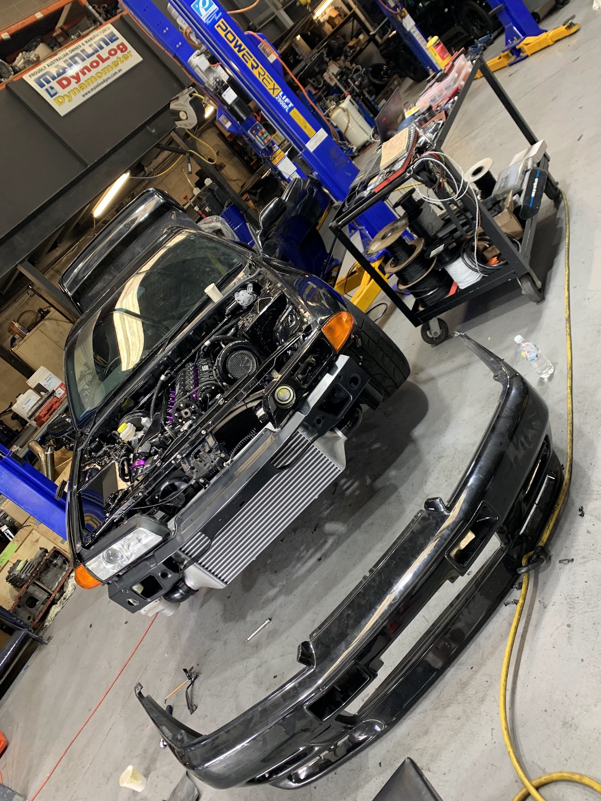Car on the hoist with the front bar off and the intercooler exposed